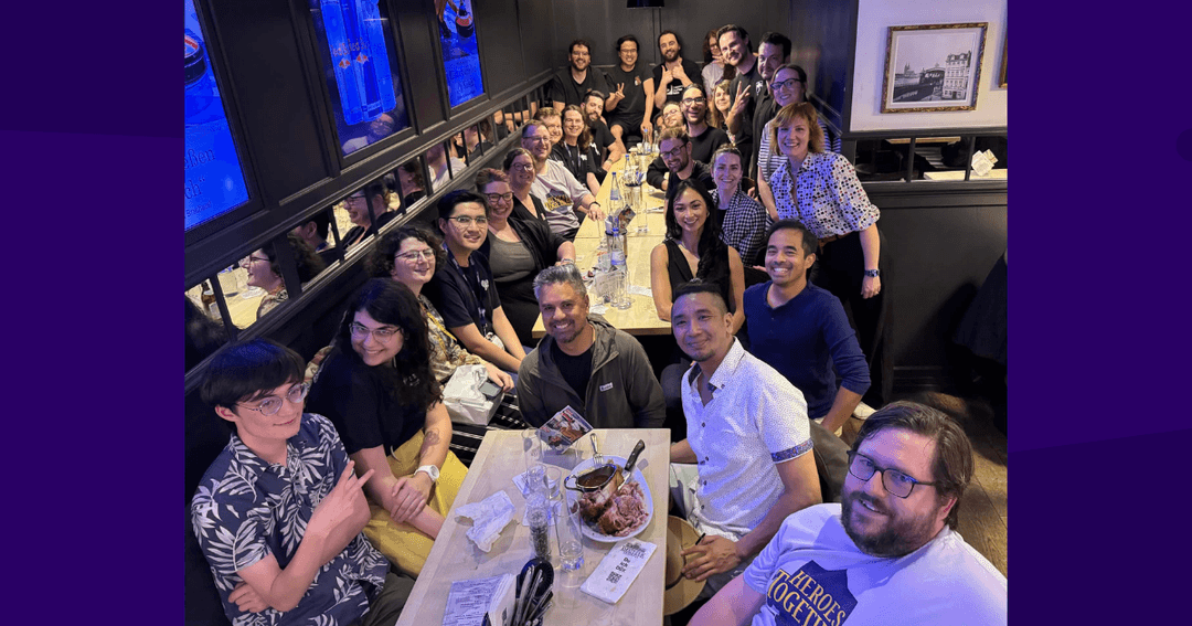 A group of Edmonton developers representing Edmonton video game studios and companies at a long restaurant table in Cologne, smiling and posing together for a group photo after Gamescom 2026.