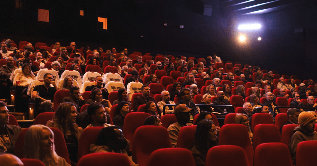 A full audience in red theatre seats at an Edmonton International Film Festival screening.