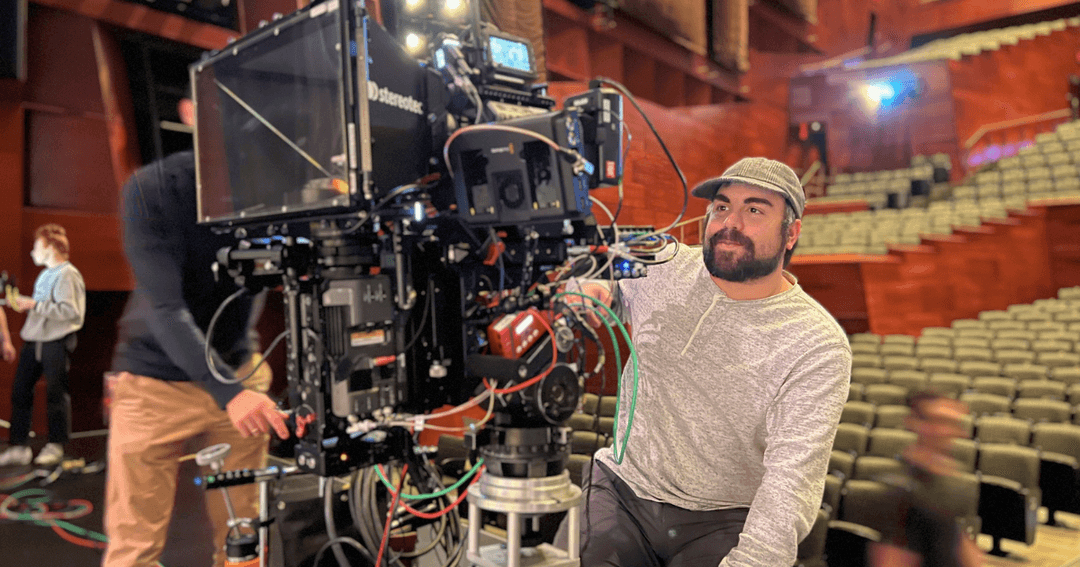 Edmonton filmmaker Dylan Pearce operating a professional cinema camera on set inside a theatre during film production